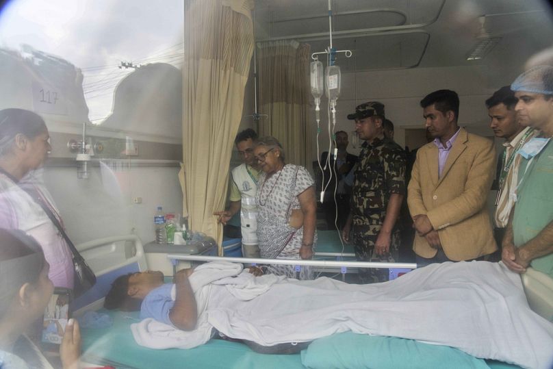 Nepal's interim prime minister Sushila Karki speaks to a person who was injured during anti-corruption protests at Civil hospital in Kathmandu, Nepal, Saturday, Sept 13, 2025.