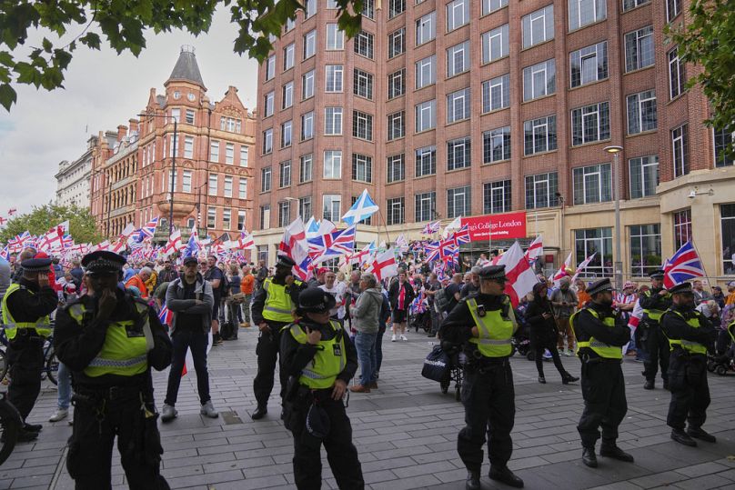 Police officers form a line in front of demonstrators from the Tommy Robinson-led Unite the Kingdom march and rally near Westminster, London, Saturday Sept. 13, 2025.