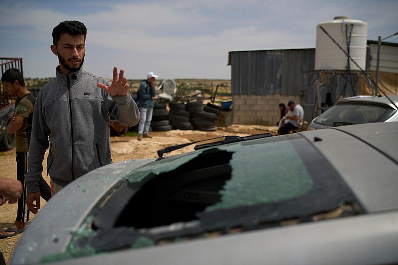 Basel Adra looks at damaged car of Palestinian co-director Hamdan Ballal, who was attacked by Israeli settlers, in Masafer Yatta, Tuesday, March 25, 2025.