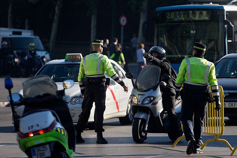 Ein Motorradfahrer diskutiert mit Polizisten in Madrid