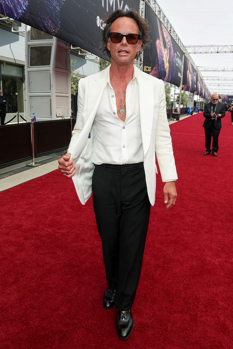 Walton Goggins kept it effortlessly cool in a cream sports coat, ivory shirt half-unbuttoned and black trousers