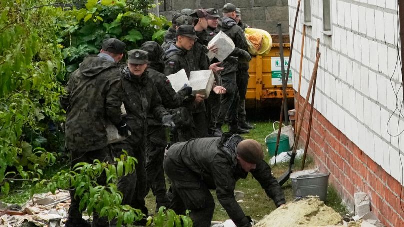 FILE: Territorial defense officers clean up debris from the destroyed roof of a house, after multiple Russian drones struck in Wyryki, Poland, Thursday, Sept. 11, 2025. 