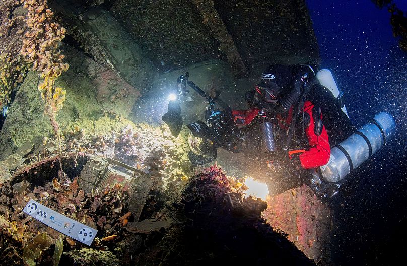 Divers illuminate the wreck's interior of the Britannic, sister ship to the Titanic