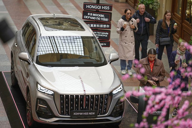 Les visiteurs passent devant une nouvelle canette chinoise Hongqi HS5 exposée à l'intérieur du grand magasin GUM près de la Place Rouge à Moscou, en Russie, le 20 mai 2025