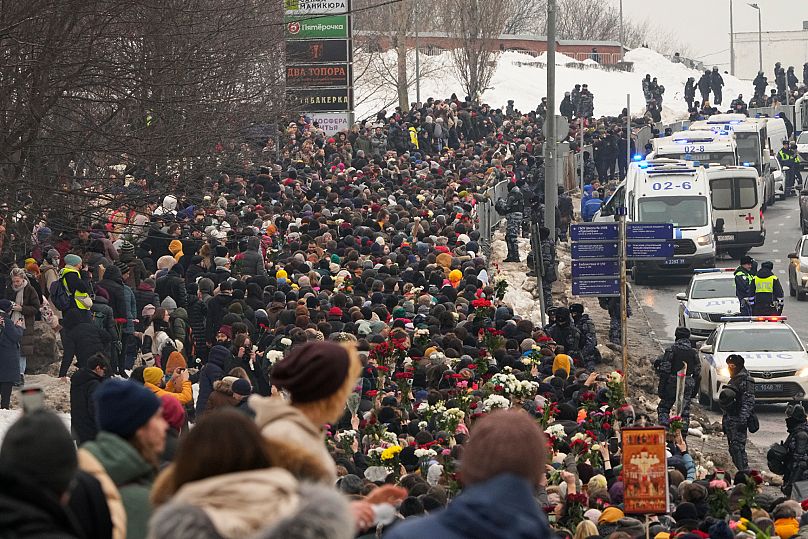 Police watch people walking toward a cemetery for the funeral of opposition leader Alexei Navalny in Moscow, 1 March, 2024