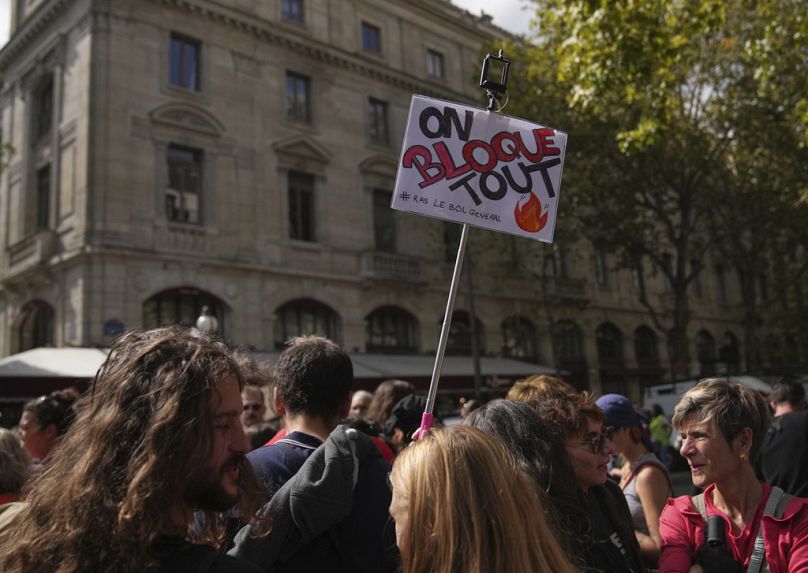 Protesters of the "Block Everything" movement gathering in Paris, Wednesday, Sept. 10, 2025. Placard reads, "block everything." (AP Photo/Christophe Ena)