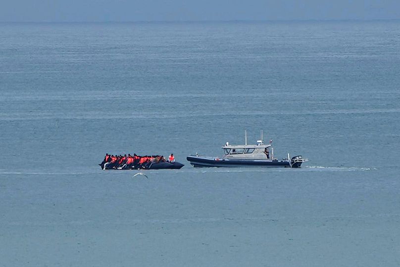 A boat thought to carry migrants is escorted by a vessel from the French Gendarmerie Nationale in the English Channel, 4 September, 2024