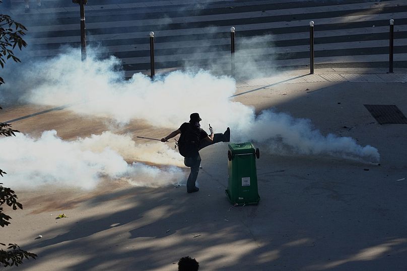 Protesters kicks a tear gas can during a demonstration called by major trade unions to oppose budget cuts in Paris, 18 September, 2025