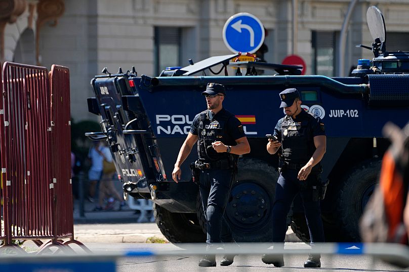 Police officers walk by a police armoured vehicle in Madrid, 8 September, 2024