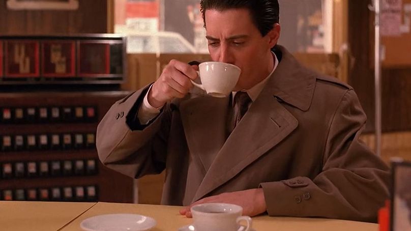Kyle MacLachlan as Agent Dale Cooper, enjoying his "damn fine" coffee at the Double R Diner. 