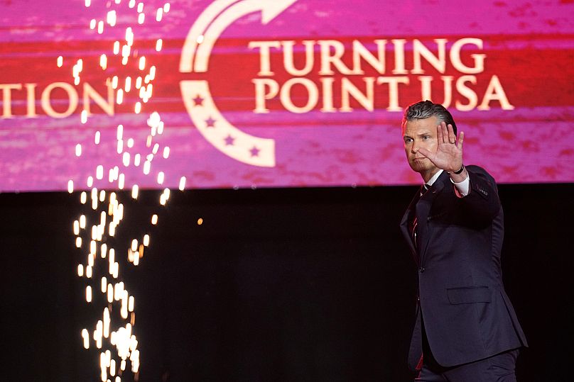O secretário de Defesa dos EUA, Pete Hegseth, sobe ao palco para discursar numa cerimónia em memória do ativista conservador Charlie Kirk, no State Farm Stadium, em Glendale