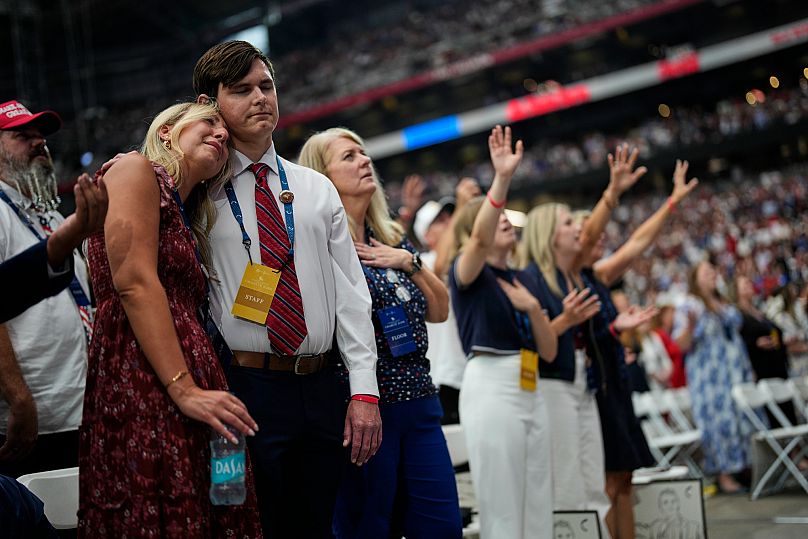 Os presentes ficam emocionados ao assistir a um vídeo em homenagem a Charlie Kirk durante uma cerimónia em memória do ativista conservador no State Farm Stadium