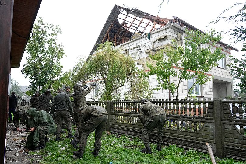 Territorial defence officers clean up debris from the destroyed roof of a house after Russian drones violated Polish airspace near Lublin, 11 September, 2025