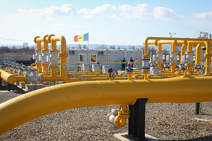 Uomini in piedi accanto alle condutture della rete nazionale di distribuzione del gas naturale fuori Ungheni, Moldova, 4 marzo 2015