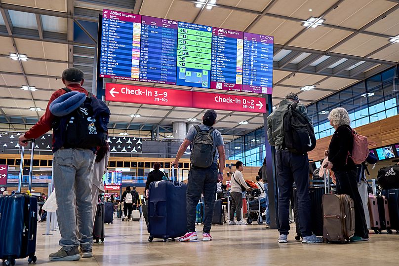 Passengers are seen in front of the check-in counters at Berlin Brandenburg Airport in Schönefeld, 22 September, 2025