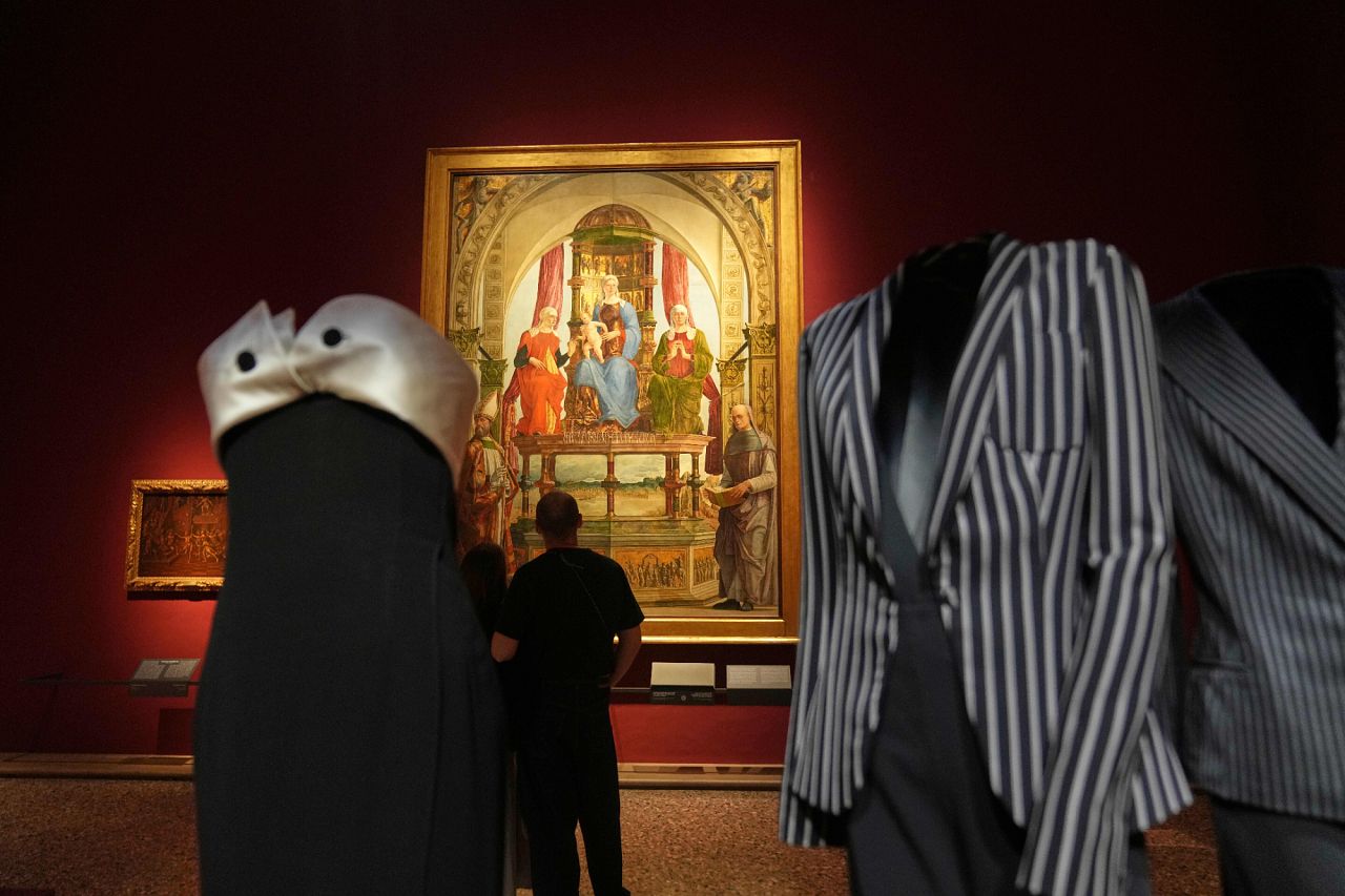 Giorgio Armani creations displayed in front of “The Virgin and Child Enthroned with Saint Anne, Saint Elizabeth, Saint Augustine, and Blessed Peter degli Onesti” 