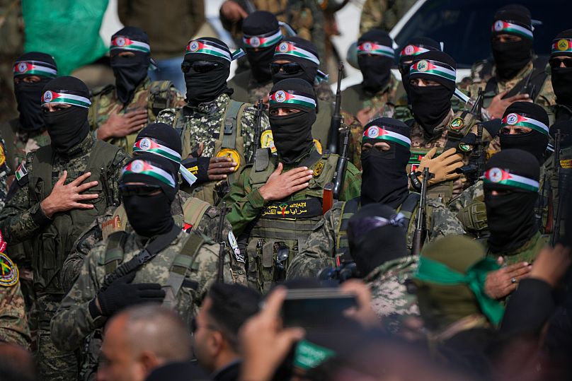 Hamas fighters stand in formation as they prepare for the ceremony of Israeli hostages hand over to the Red Cross in Nuseirat, 22 February, 2025