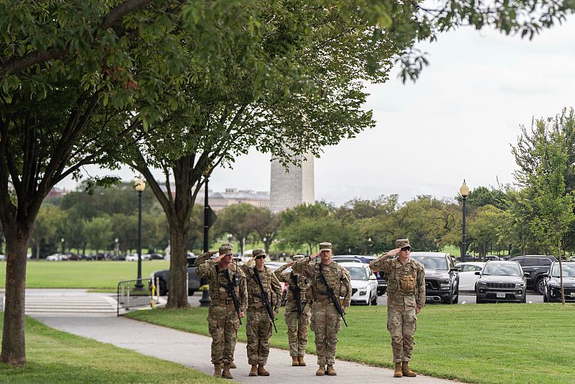 FILE: US National Guard soldiers salute as President Donald Trump's motorcade drives by in Washington, 20 September 2025