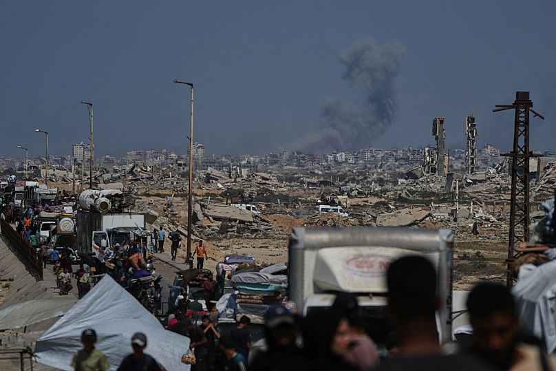 Des volutes de fumée s'élèvent au-dessus de la ville de Gaza à la suite d'une attaque aérienne israélienne, alors que des Palestiniens déplacés fuient le nord de Gaza, 24 septembre 2025.