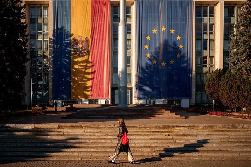 Une femme marche devant le bâtiment du gouvernement décoré à Chișinău, le 26 septembre 2025.