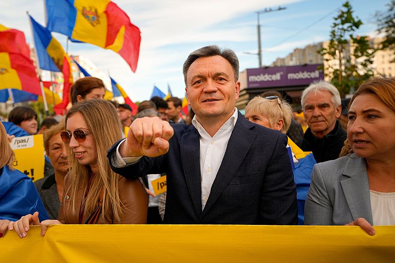 Moldova's Prime Minister Dorin Recean raises his fist next to supporters during a pro-EU rally of the ruling Party of Action and Solidarity in Chișinău, 26 September, 2025