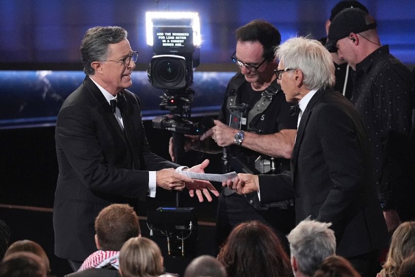 Stephen Colbert átadja életrajzát Harrison Fordnak az Emmy-gálán Los Angelesben, 2025. szeptember 14-én
