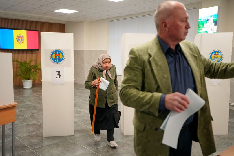 A woman exiting a voting booth waits in line to cast her vote during a parliamentary election, in Chisinau, Moldova, Sunday, Sept. 28, 2025