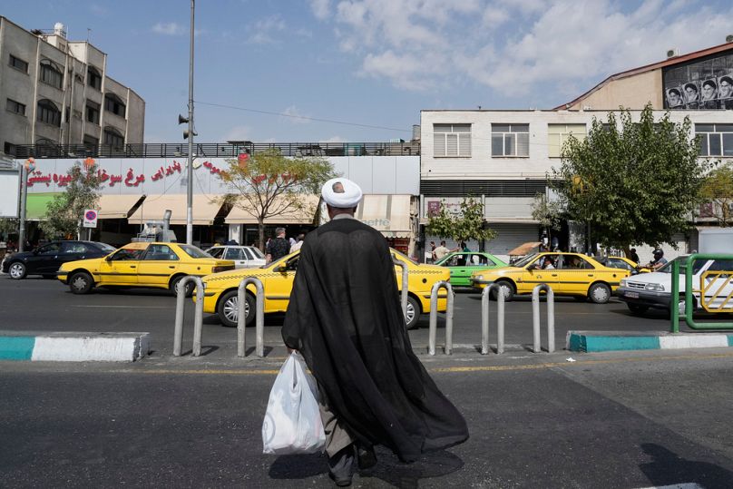  A cleric crosses the Enqelab-e-Eslami (Islamic Revolution) street, in Tehran, Iran, Saturday, Sept. 27, 2025