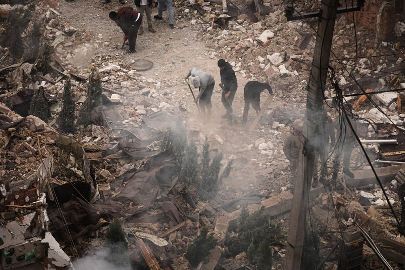 People clear the rubble at the site of an apartment buildings damaged during a Russian attack in Kyiv, Ukraine, Sunday, Sept. 28, 2025