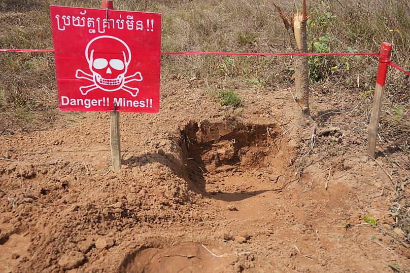 A sign marks an area as Cambodia Mine Action Centre staff work at a minefield in Preytotoeung village, 19 January, 2023