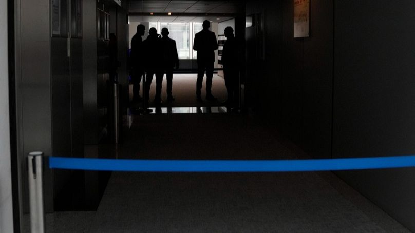 FILE: Security officers gather in a corridor after searching the office of German MEP Maximilian Krah at the European Parliament in Brussels, Tuesday May, 7, 2024