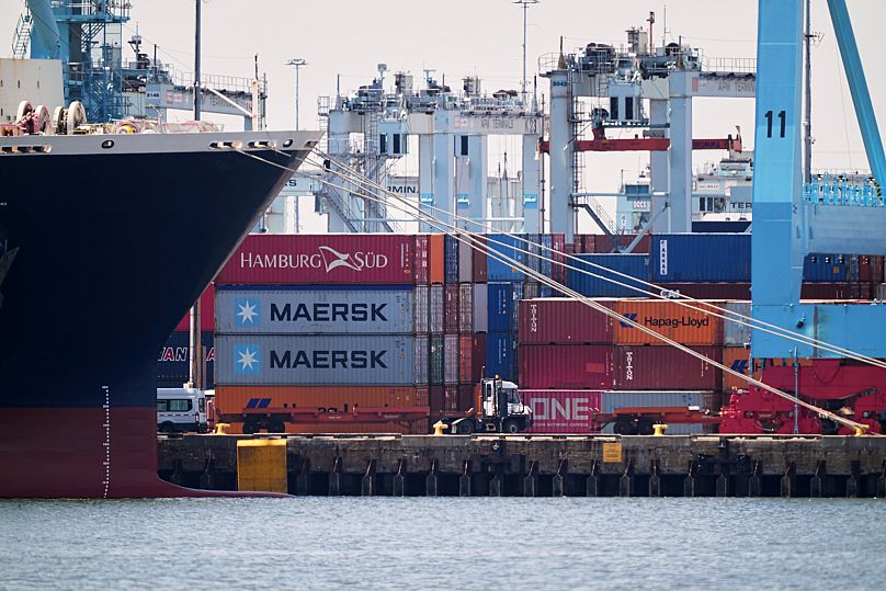 A truck drives by shipping containers at the port of New York & New Jersey. (AP Photo/Matt Rourke)