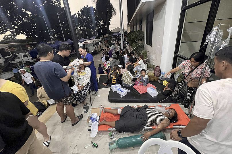 Des patients attendent devant l'hôpital de Cebu à Bogo City après un violent séisme qui a frappé la ville, dans la province de Cebu, au centre des Philippines