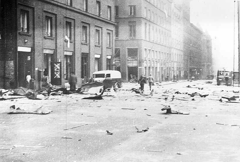 People rush around and debris litters a street in Helsinki after a Soviet bomber raid, 9 December, 1939