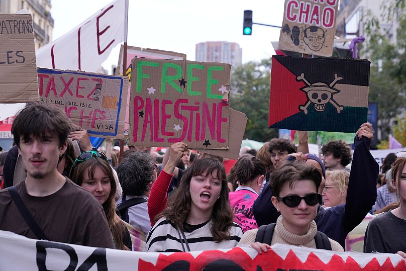 Varios jóvenes portan carteles tanto en favor de Palestina como contra las políticas de austeridad anunciadas por Macron, el 2 de octubre de 2025 en París. 