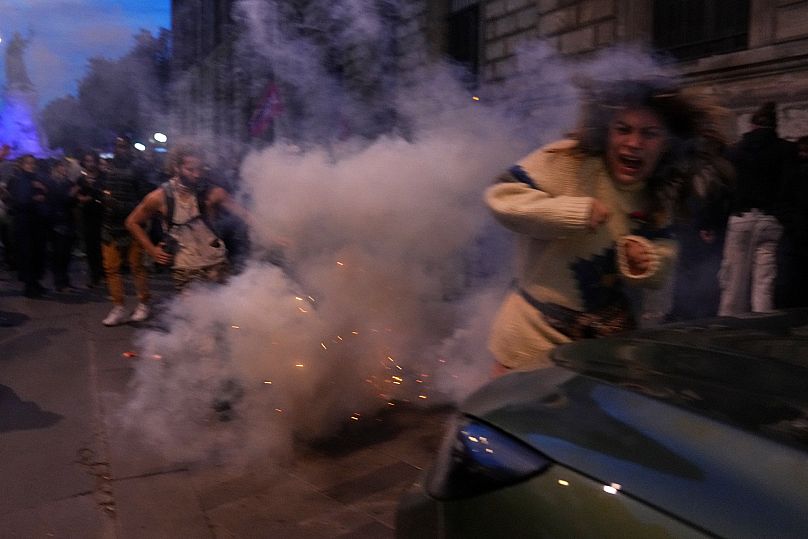 Um manifestante tenta evitar o gás lacrimogéneo durante uma manifestação em Paris, França, quinta-feira, 2 de outubro de 2025.