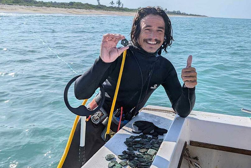 Le plongeur Levin Shavers montre des pièces de monnaie découvertes dans une épave espagnole au large de la côte atlantique de la Floride