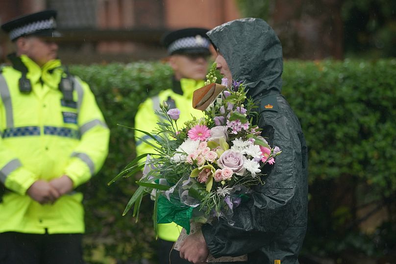 A woman brings flowers as she attends a vigil for the victims of the attack on the Heaton Park Hebrew Congregation synagogue in Manchester, 3 October, 2025