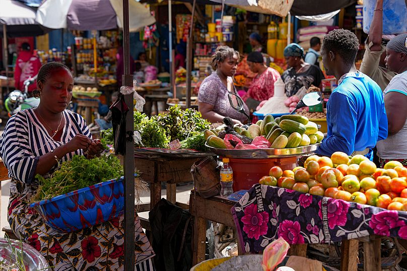 A vegetable seller sorts fresh produce at a market in Conakry, Guinea.