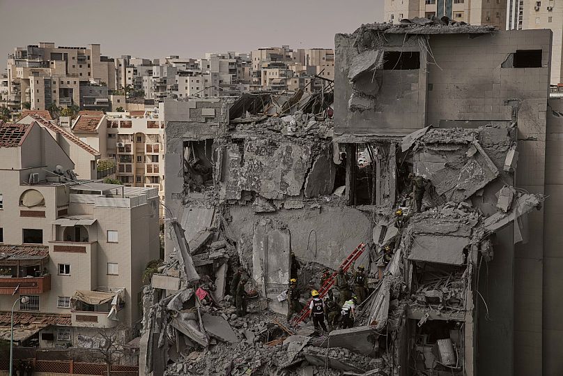 Rescatistas trabajan entre los escombros de edificios residenciales destruidos por un ataque mortal con misiles iraníes en Beersheba, Israel, martes 24 de junio de 2025.