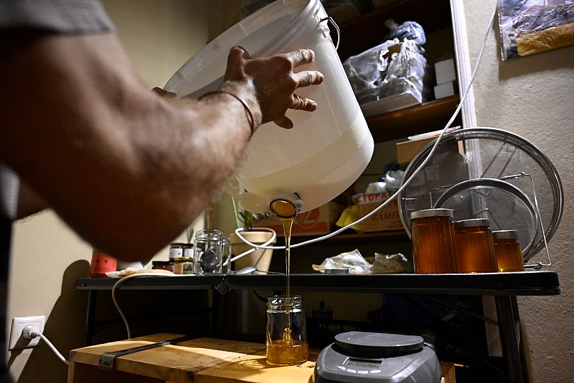 Nikos Chadjilias fills a jar with honey in the Zografou suburb of Athens, Greece.