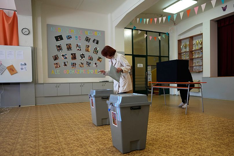 A woman casts her ballot for a general election at a poling station in Brno, 3 October, 2025