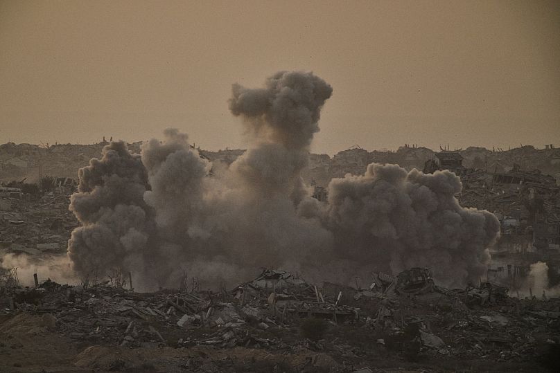 Buildings that were destroyed during the Israeli ground and air operations are engulfed by smoke following a strike in northern Gaza, 3 October, 2025