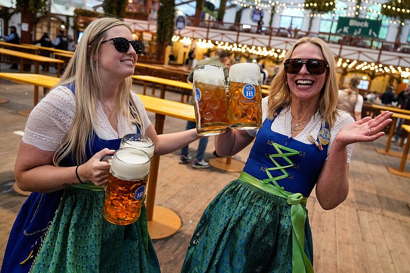 Waitresses celebrate in a beer tent after the re-opening of the Oktoberfest in Munich, 1 October, 2025