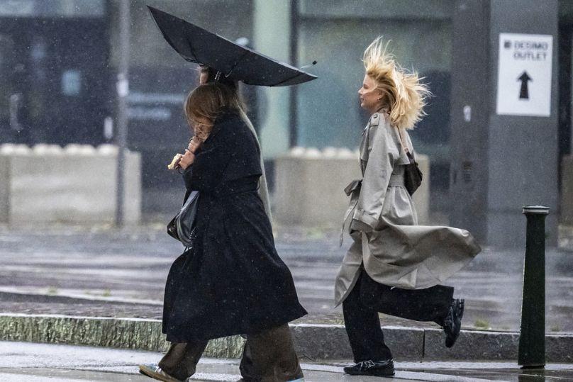 People struggle against the wind and rain in Malmö, Sweden, after a storm reached southern Sweden, Saturday Oct. 4, 2025. (Johan Nilsson/TT via AP)