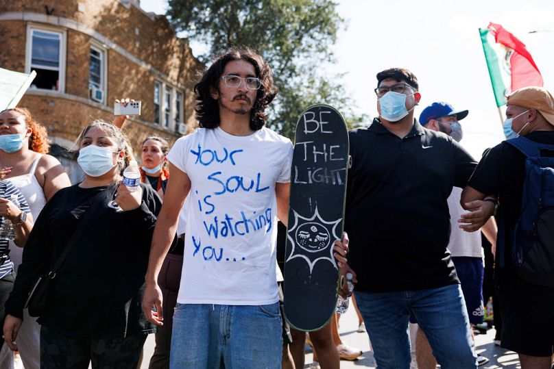 Demonstrierende stehen am Samstag, dem 4. Oktober 2025, im Stadtteil Brighton Park in Chicago, nachdem bekannt wurde, dass die US-Grenzschutzbehörde eine Frau angeschossen hat