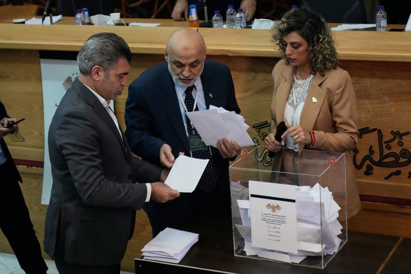 Syrian election officials count ballots shortly after polling stations closed at Latakia's Governor building, in the coastal city of Latakia, Syria, Sunday, Oct. 5, 2025