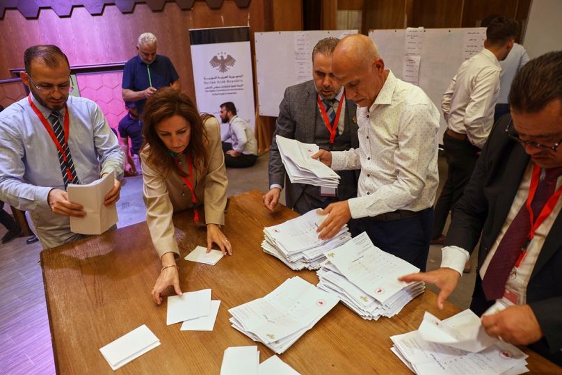 Officials count the votes of electoral college members in a parliamentary election at a polling station in Aleppo, Syria, Sunday, Oct. 5, 2025