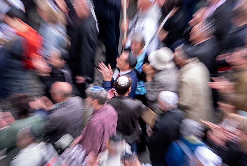 Pessoas de diferentes religiões usam o kippah judeu durante uma manifestação contra o antissemitismo em Erfurt, 25 de abril de 2018