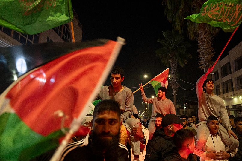 Ehemalige palästinensische Gefangene, die von den israelischen Behörden freigelassen wurden, schwenken palästinensische und Hamas-Flaggen, in Beitunia, Westjordanland.
